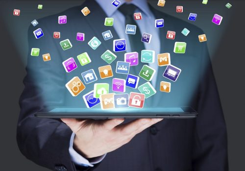 Businessman holding a tablet pc with mobile applications icons on virtual screen . Internet and business